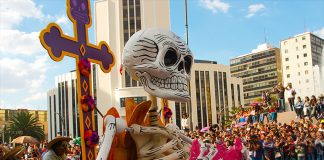 A woman pushes a float at the Mexico City's 2016 Day of the Dead parade.