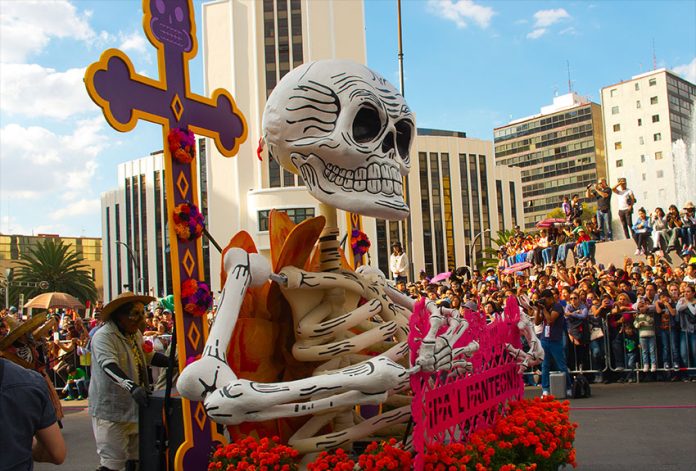 A woman pushes a float at the Mexico City's 2016 Day of the Dead parade.