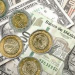 U.S. dollar bills with Mexican peso bills and coins.