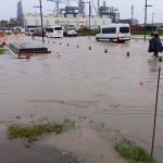 Workers wade through calf-high water outside the Dos Bocas refinery.