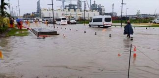 Workers wade through calf-high water outside the Dos Bocas refinery.