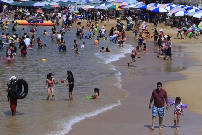 Tourists enjoy the beach in Acapulco, in July of this year.