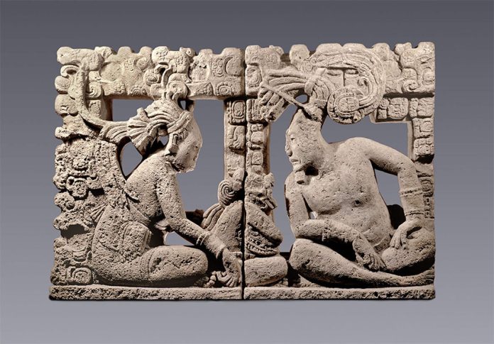 A lord and his companion observe a small supernatural creature seated between them in this intricately carved backrest for a throne.