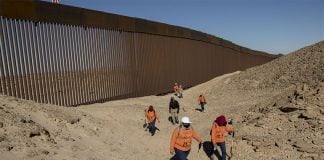 The International Search Brigade for Disappeared Persons searches for signs of their loved ones along the Mexico-US border wall outside of Mexicali, in an area where migrants frequently cross.