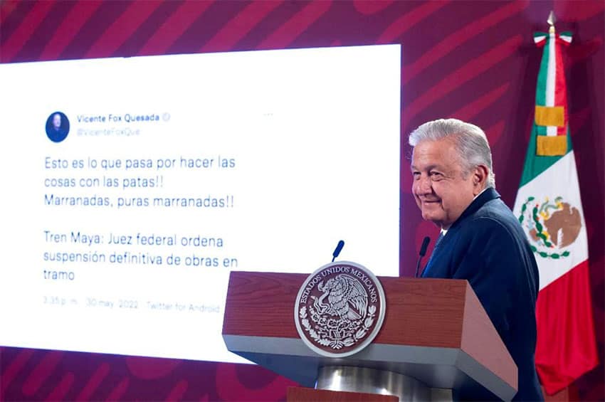 President López Obrador at a podium in front of a projection of a tweet from former president Vicente Fox.