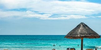 Tourists swim and lounge on a Cancún beach.