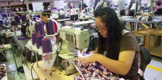 A woman assembles clothing in a maquila, a factory that uses imported materials to assemble products for export.