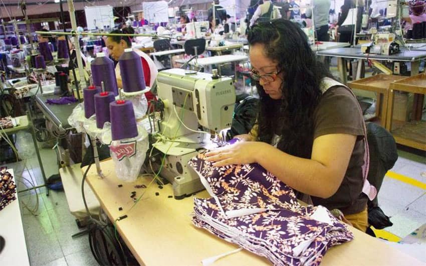 A woman assembles clothing in a maquila, a factory that uses imported materials to assemble products for export.