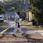 A forensic worker cordons off the scene of a double homicide in Morelos, in December 2021.