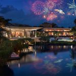 The Rosewood Mayakoba's beachfront resort, "Aquí Me Quedo," with fireworks in the sky above.