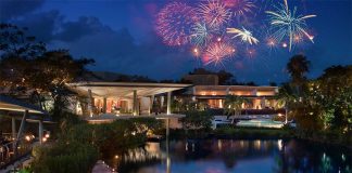 The Rosewood Mayakoba's beachfront resort, "Aquí Me Quedo," with fireworks in the sky above.