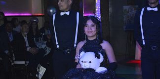 Mexican quinceañera posing with her traditional "last toy"