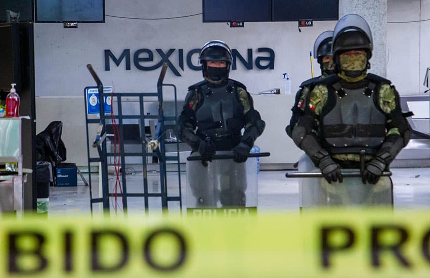 Mexican military guarding Mexicana airline ticket booth in Mexico City International Airport from former employees of airline.