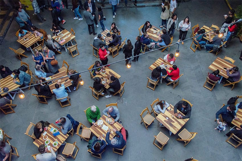 An overhead view of diners seated at wooden tables in Mexico City.