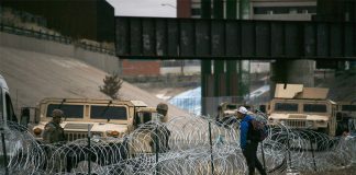 A 16-year-old boy hoping to enter the U.S. approaches the barricades on the border between Chihuahua and Texas.