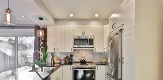 A view of a kitchen with a refrigerator, microwave, stove and other appliances.