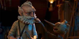 A screenshot from "Pinocchio" in which the wooden puppet, awestruck, reaches out to touch the nose of the old man who created him.