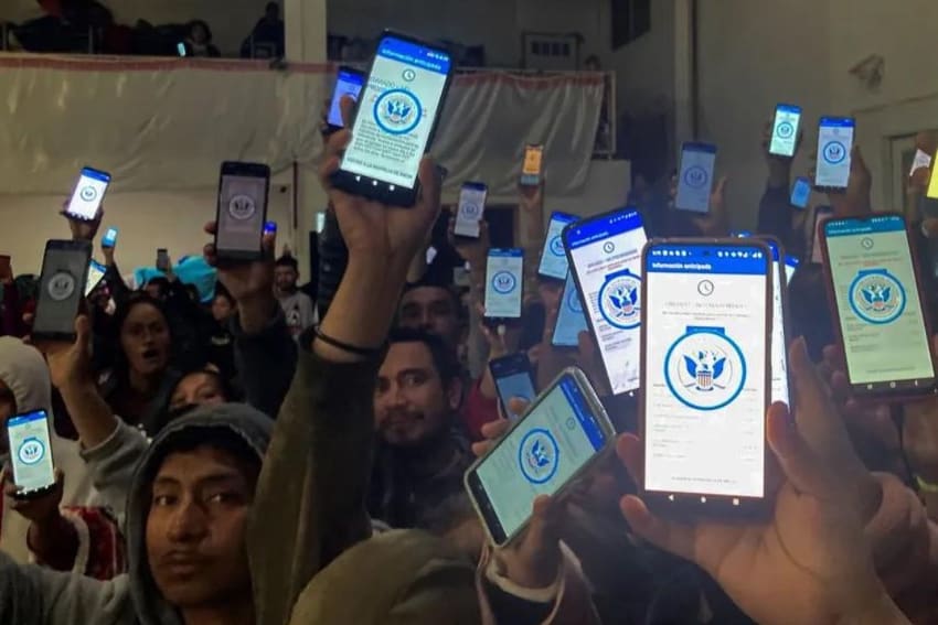Migrants show the CBP One app on their phones