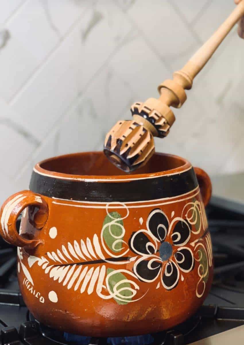Traditional Mexican clay pot with molinillo mixer