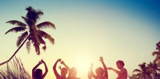 Spring break vacationers parrty on a beach.