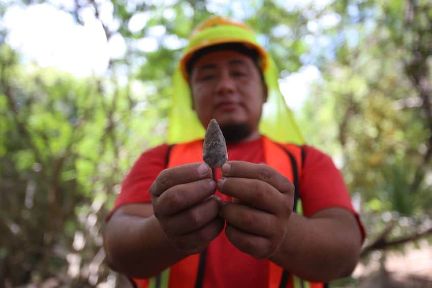 Mexican archaeologist holding newly discovered Mayan artifact