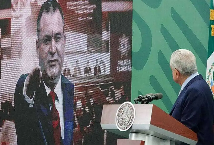 President Lopez Obrador with image of ex-security minister Genaro Garcia Luna