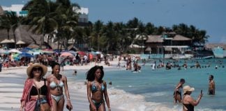 Tourists walk down the beach at Playa del Carmen