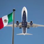 Plane flying over Mexican flag