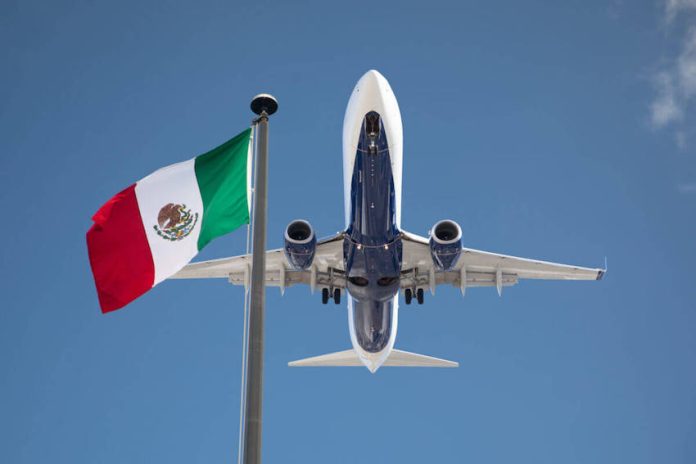 Plane flying over Mexican flag