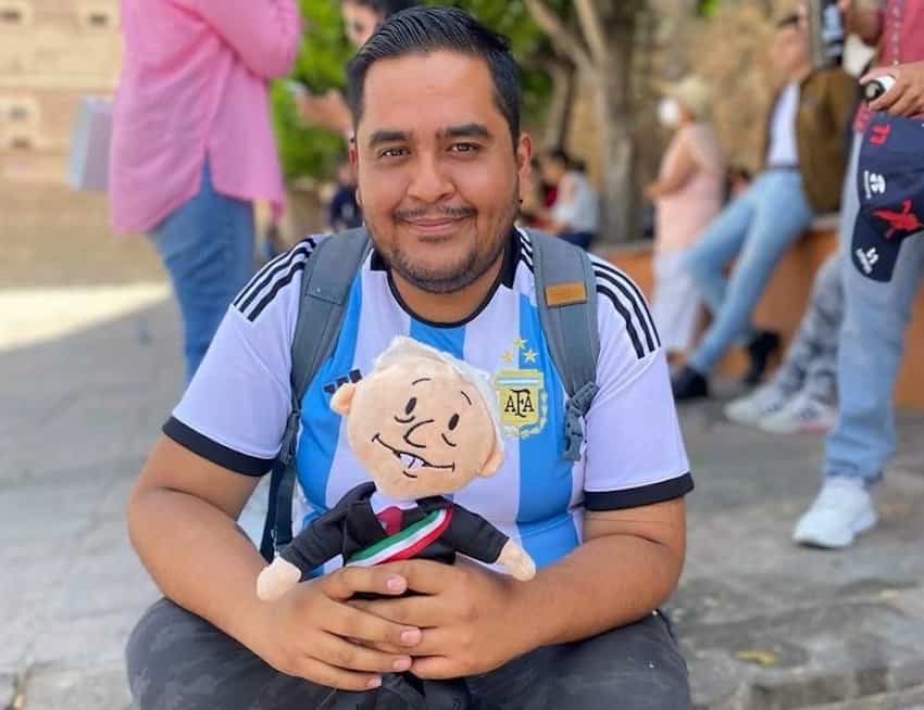 Fausto Martínez holding an AMLO doll.