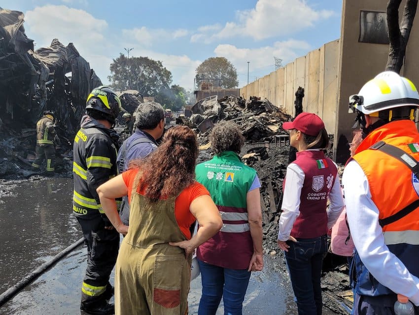 Officials inspect the site of the fire in the central de abasto.