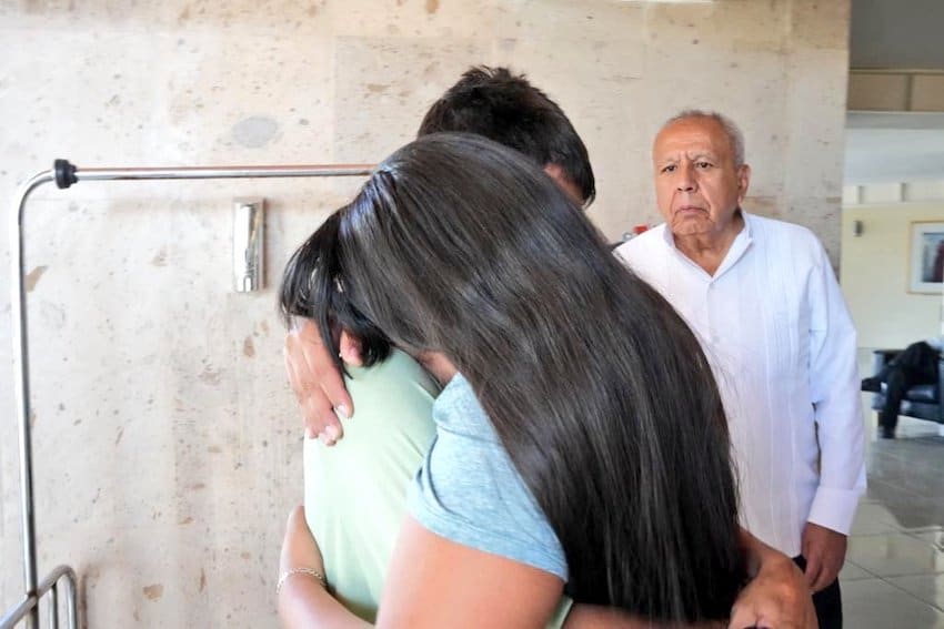 Garduño looks on at a crying couple after the fire in Chihuahua.