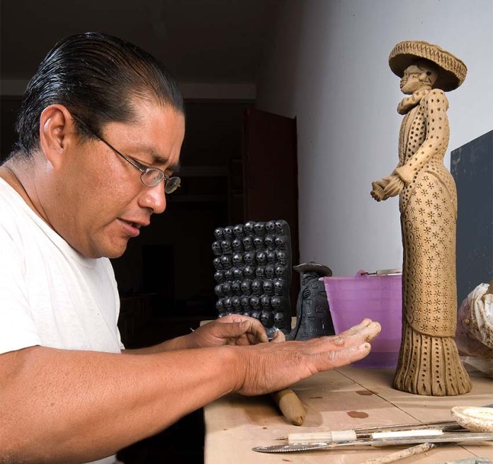 Sculptor Carlomagno Pedro working in his studio.