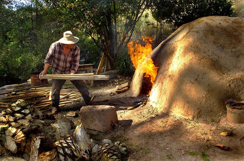 Man feeds wood-fire oven.