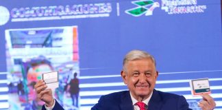 AMLO holds up Finabien cards at the mañanera.