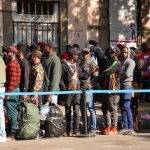 Haitian migrants wait in a queue