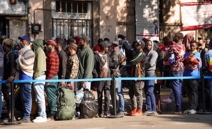 Haitian migrants wait in a queue