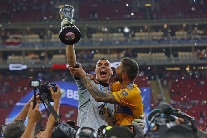 Tigres holding up the trophy.