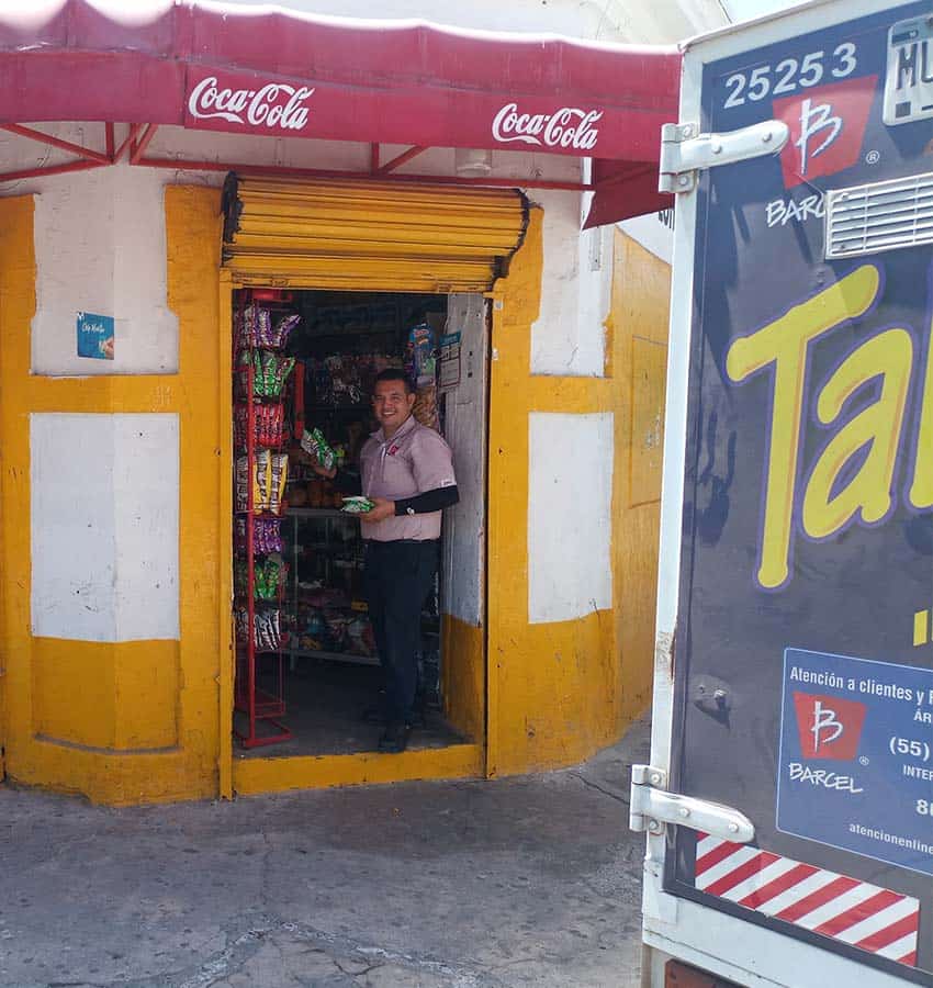 A man stands in the door of a tienda de abarrotes.
