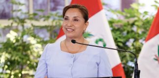 Dina Boluarte with a Peruvian flag