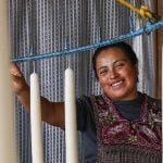 A woman smiling next to candles