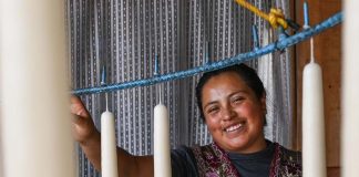 A woman smiling next to candles