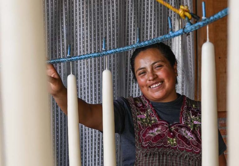 A woman smiling next to candles