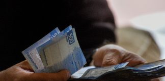 Man holding Mexican pesos