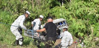 Police rescuing an injured person from bus crash in Nayarit