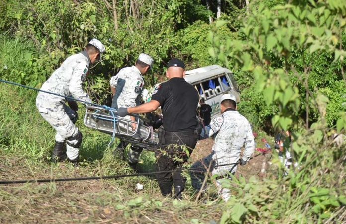 Police rescuing an injured person from bus crash in Nayarit