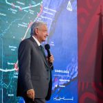 AMLO standing in front of map of Maya Train