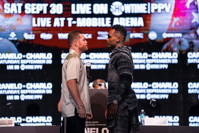 Canelo and Charlo stand face to face in front of a digital screen with information about their fight.