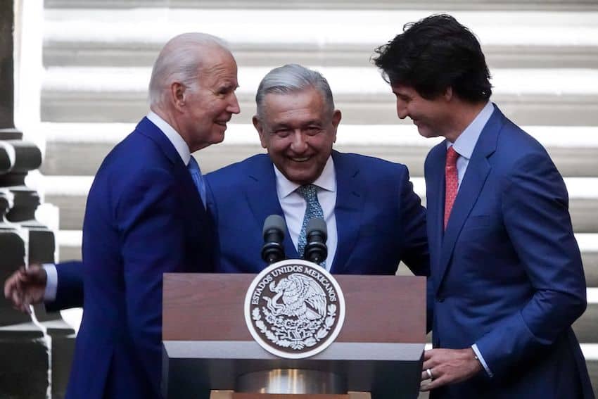 Biden, AMLO and Trudeau huddle at a podium