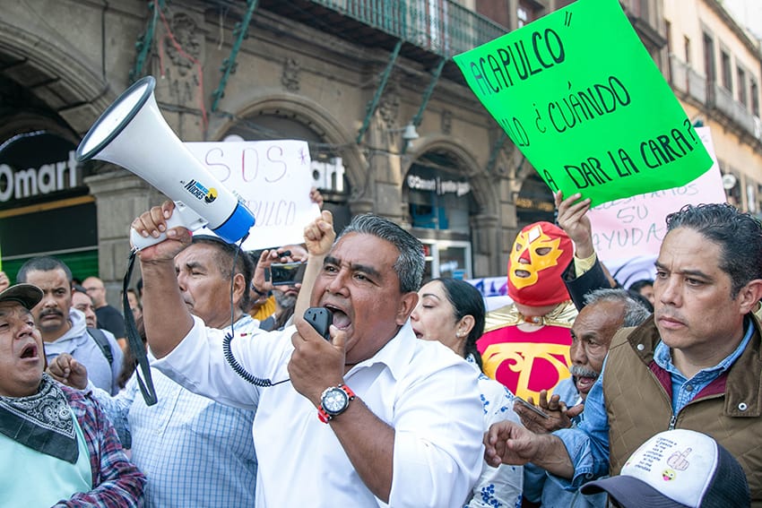 A man shouts into a megaphone at a protest.